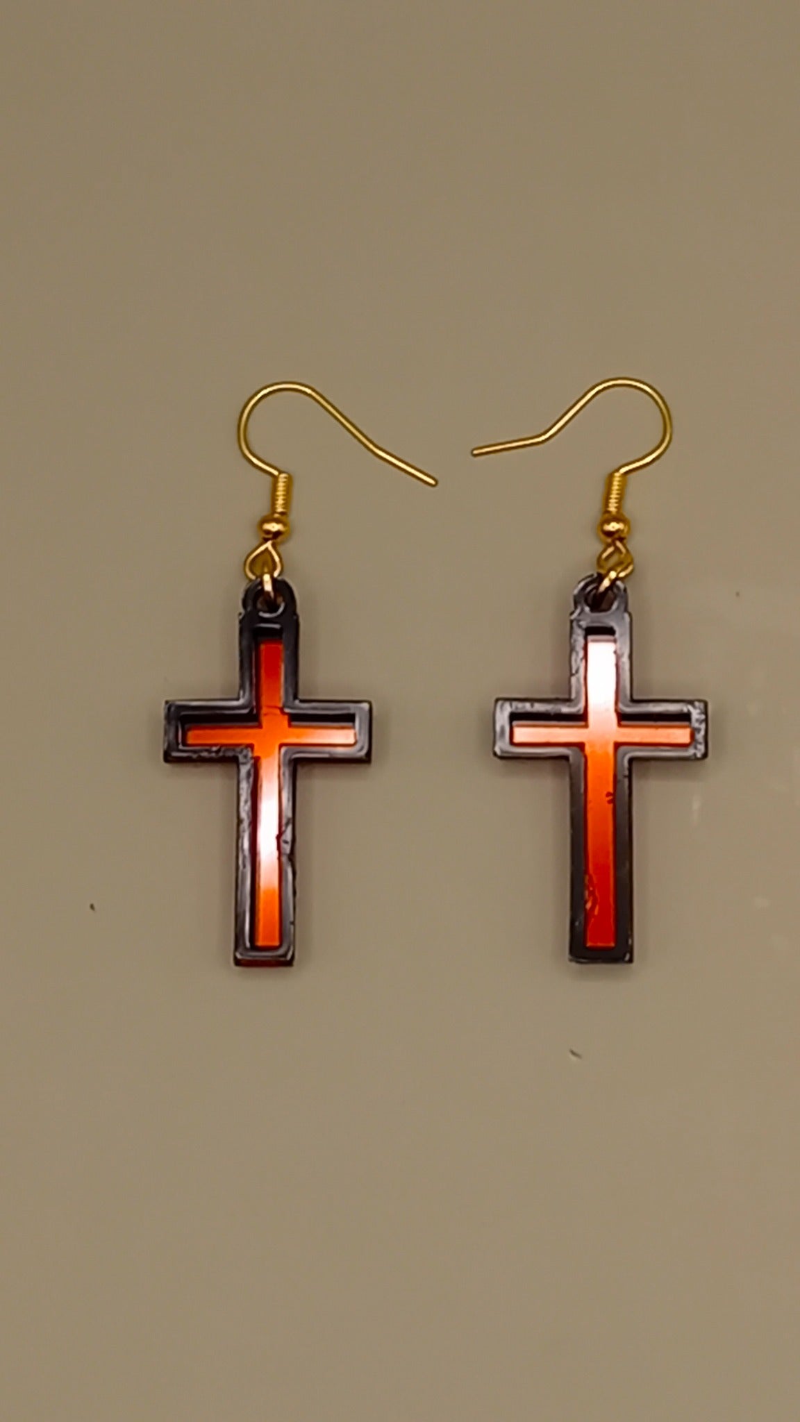 Red mirrored acrylic cross earrings with black layered frame and gold hooks