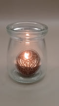 Engraved gothic glass votive candle holder lit with a tea light