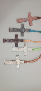 Rustic engraved wooden Celtic cross pendants showing natural workshop marks and varied finishes